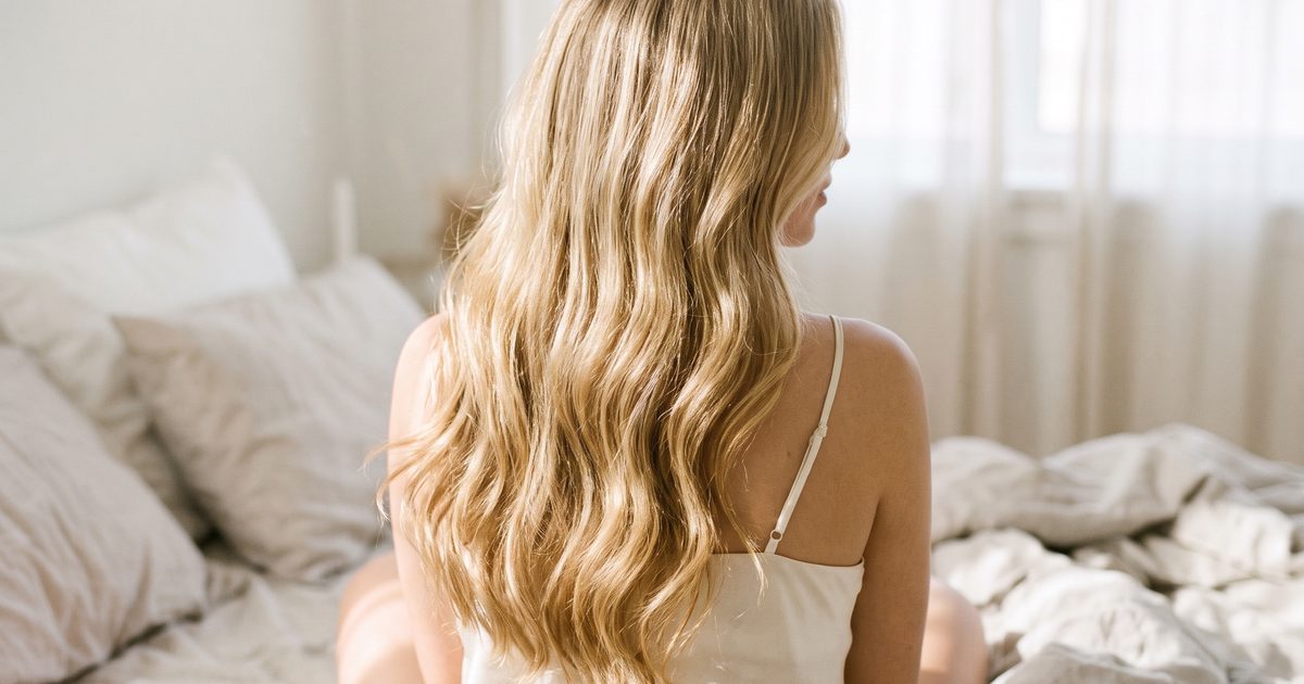Woman with long healthy blonde hair from behind, showing the hair health collagen supports during weight loss treatment